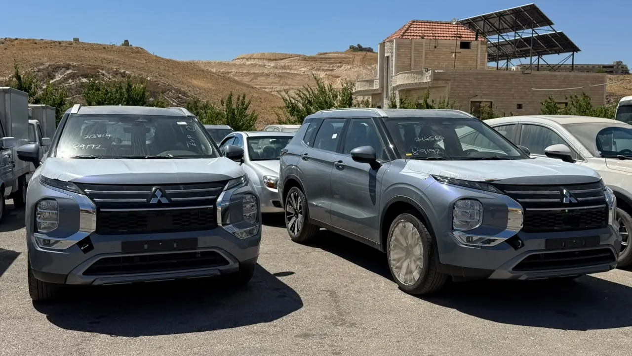 سيارتان من نوع SUV باللون الرمادي في ساحة عرض خارجية تحت أشعة الشمس